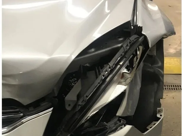 A silver Chevy Equinox with its fender and headlight crushed