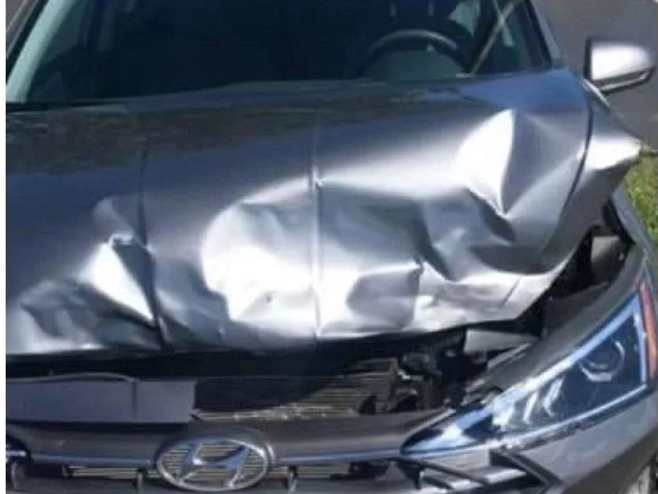 A gray Hyundai sedan with its hood crumpled after a front-end crash