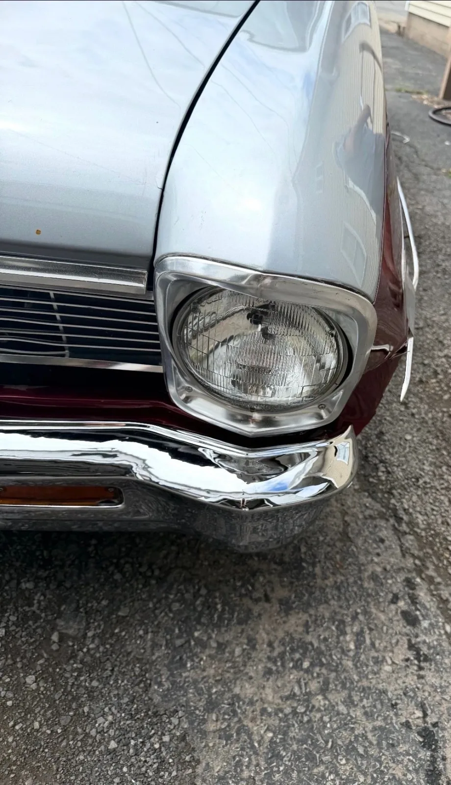 A headlight and chrome trim on the restored Chevy II