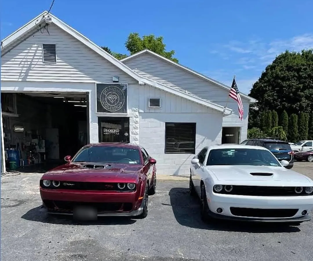 The shop at 54 Donovan Street, with its round diamond sign over the door and two cars parked out front