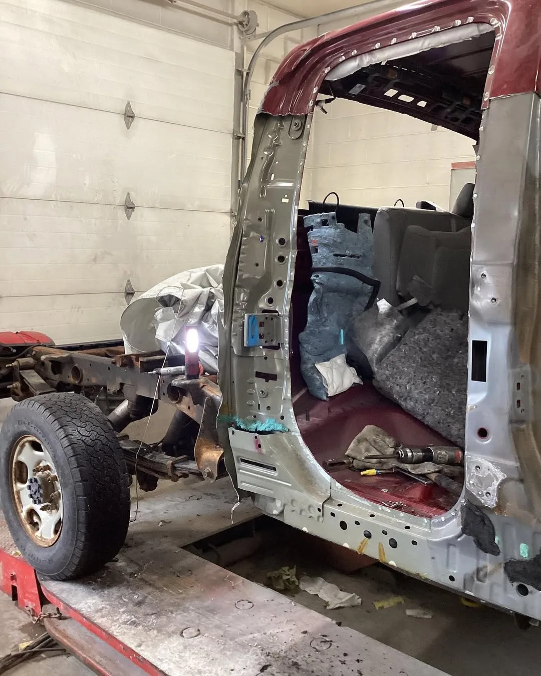 A pickup’s cab with the side stripped back to the frame for a new door pillar